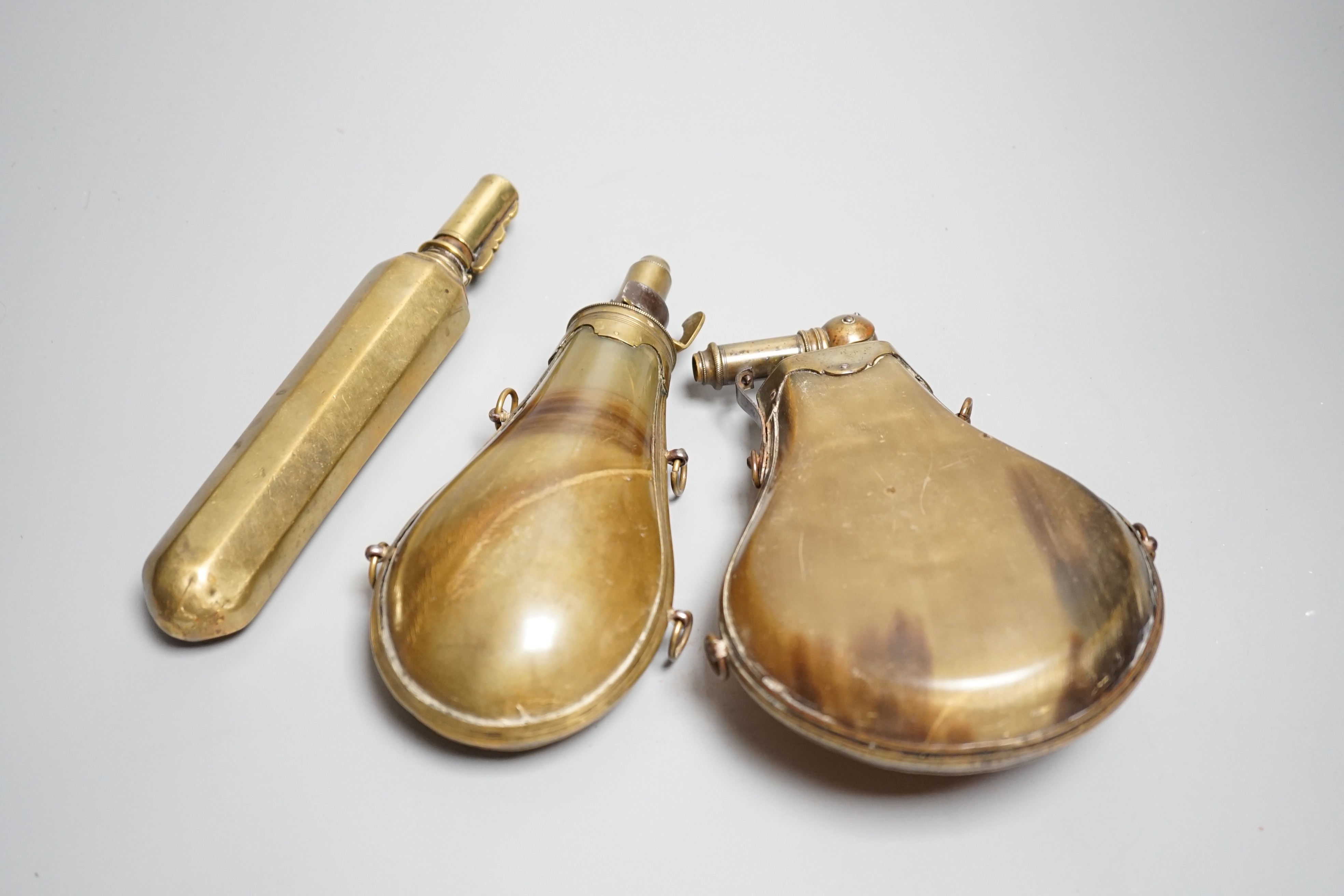 Two French lant horn powder flasks with brass mounts c.1800, one with graduated folding charger, and another unusual octagonal brass powder flask. Maximum 20cms